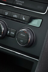 Przycisk pokrętło regulacji temperatury w aucie samochodzie w czystym wnętrzu auta © VILKTERIO