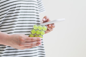 Female hand holding blister of lozenges with cough drops and smartphone.