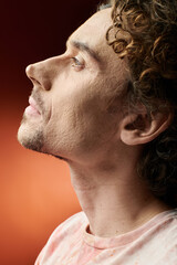 Fototapeta premium A man displays deep emotion while posing against a colorful background.