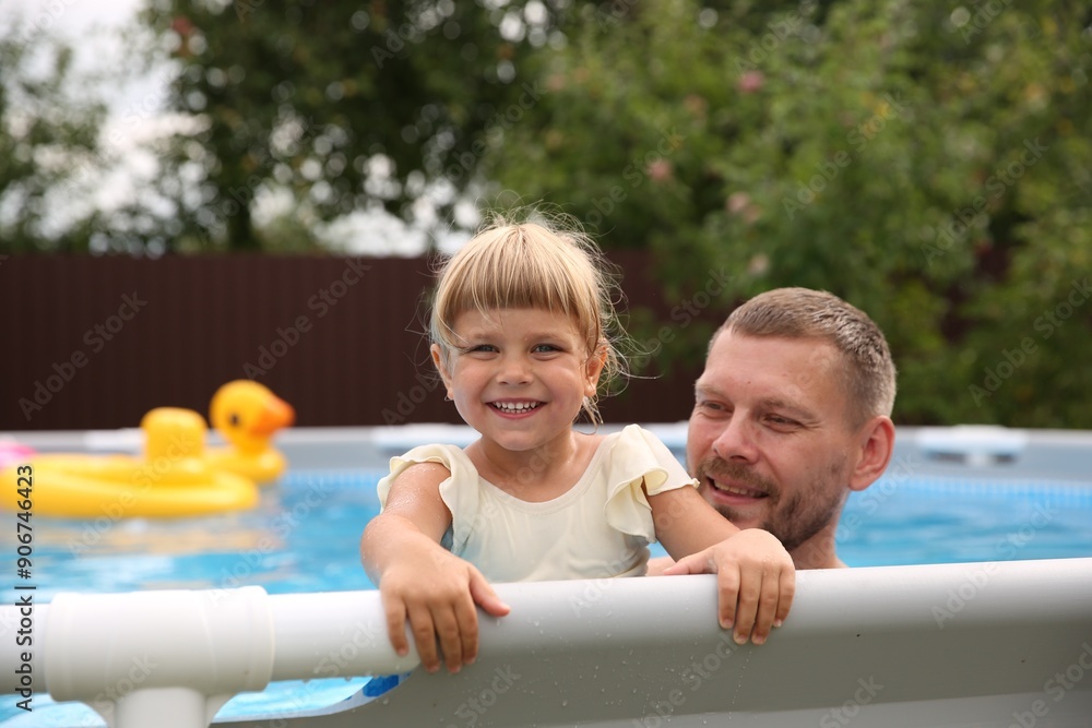 Sticker happy daughter and her father resting in swimming pool