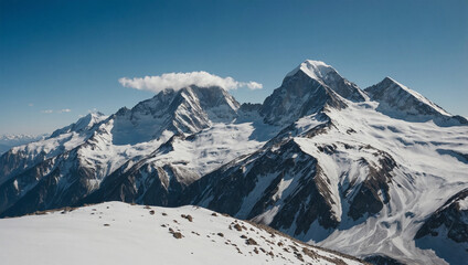 Fototapeta premium View of high mountains with snowy peaks under a clear blue sky