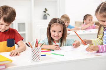 Group of children drawing at table indoors