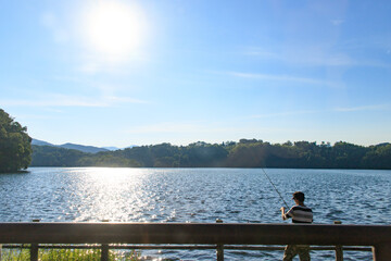 Serene Lakeside Fishing at Sunset with Sparkling Waters