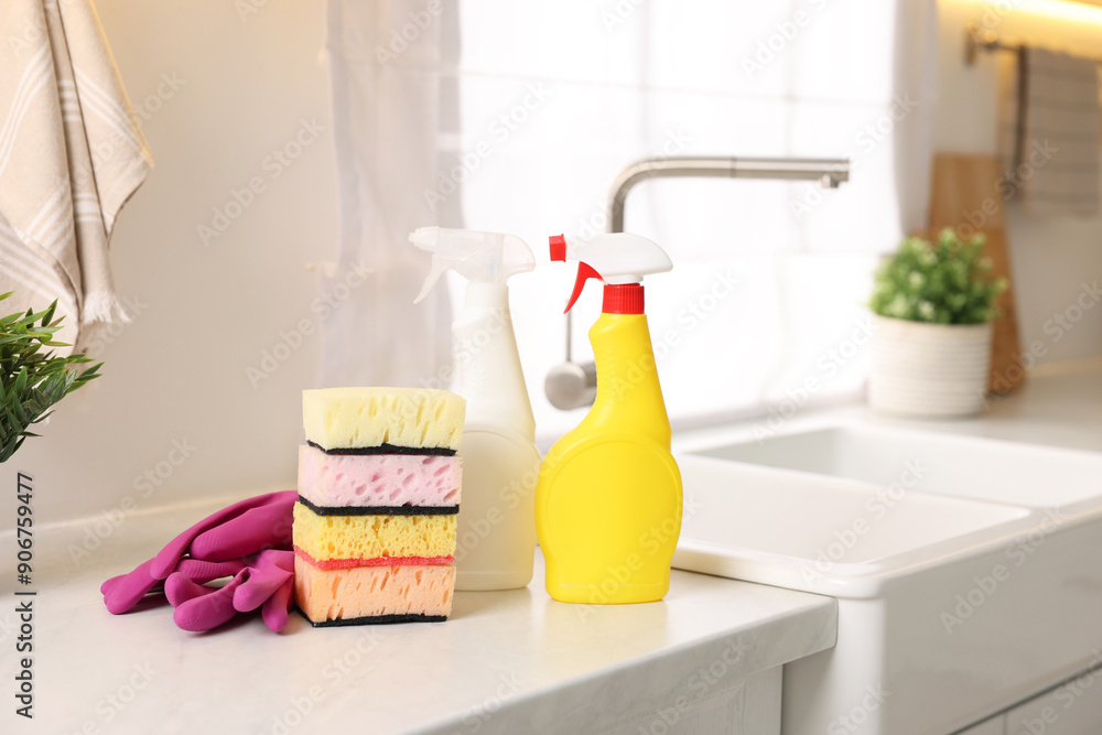 Sticker cleaning service. detergents, sponges and gloves on table in kitchen