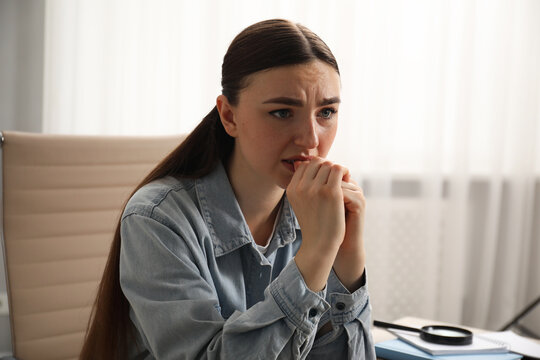 Embarrassed woman in denim jacket in office