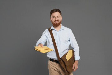 Postman with brown bag delivering letters on grey background