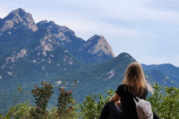 Naklejka premium The girl looks at the mountain tops.