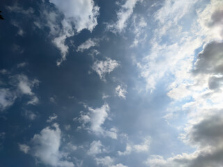 Obraz premium The sky, adorned with the sun hidden behind wispy clouds, creates a mesmerizing play of light and shadow.