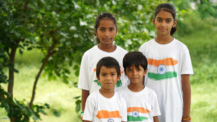 Young and Little Indian holding or waving Indian Tricolor Flag celebrating Independence day or Republic day