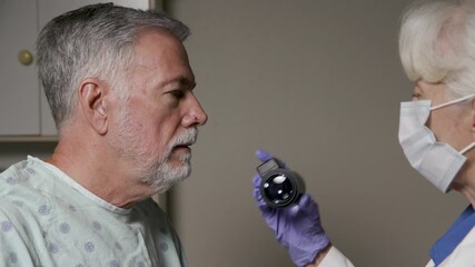 closeup senior man getting a spot on his nose examined  by a dermatologist