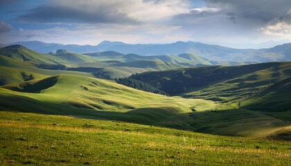 A tranquil highland plateau with expansive views of rolling green fields and distant mountain ranges under a soft, overcast sky.

