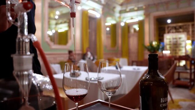 Elegant setting in a high-end hotel featuring a unique wine decanting apparatus. Vintage Kopke Colheita 1980 wine being served amidst ornate decor.