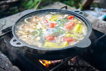 Food cooked in a cast-iron cauldron over a fire. Cooking food while traveling in the camp.
