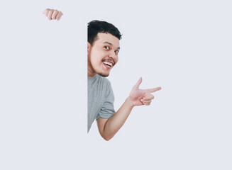 happy shocked expression of asian man pointing finger while holding banner blank signboard or...
