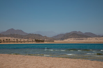 Sandy beach on the seashore. Desert at sunset. Yellow sand. Beautiful sky.