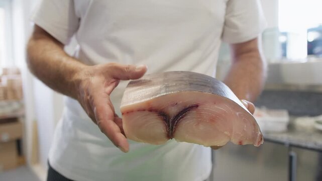 Chef Massages Swordfish Fillet Before Slicing It In A Restaurant