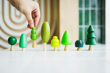 Conservationist or businessman is placing tree model on table, concept of nature conservation or...