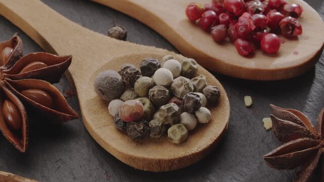 Various types of spices on wooden spoons slowly move along the frame, a great food background for your projects.