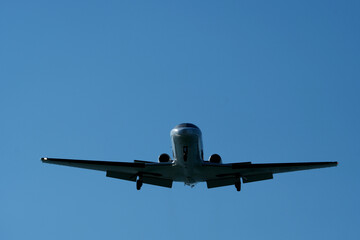 Airplane in the blue sky. Airplane in the sky. Airplane in flight over the blue sky. Traveling concept.