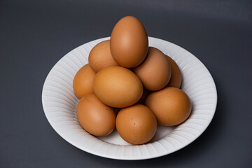 White plate with arrangement of raw chicken eggs. Raw chicken eggs for cooking purposes.