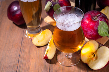 Glasses with Sour Sweet fruit Apple Craft Beer, Cider or Ale on wooden table with fresh red apple slices