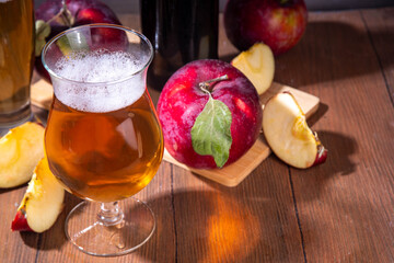 Glasses with Sour Sweet fruit Apple Craft Beer, Cider or Ale on wooden table with fresh red apple slices