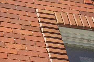 Vintage red brick work with beveled edge bricks going round a window