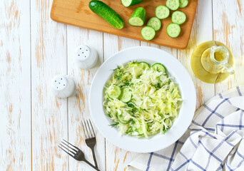Vegetarian salad. Spring vegan salad with cabbage, cucumber and dill. Top view, flat lay, overhead.