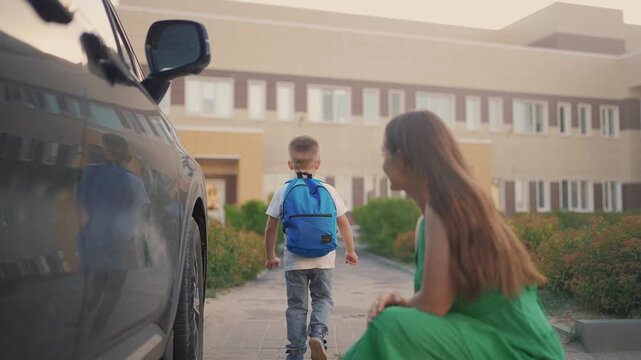 Back to school. Mom meets her son at school. Child mother family concept. Mom brings lifestyle her boy son back to. school. Mom returns her son to. school. education concept.