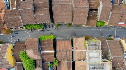 Aerial view of traditional Asian village with tiled rooftops and narrow street reflecting cultural...