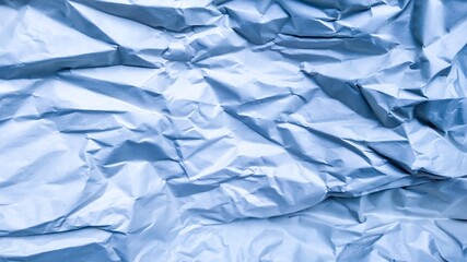 Obraz premium Crumpled blue paper texture background, ideal for recycling or environmental sustainability concepts and Earth Day promotions