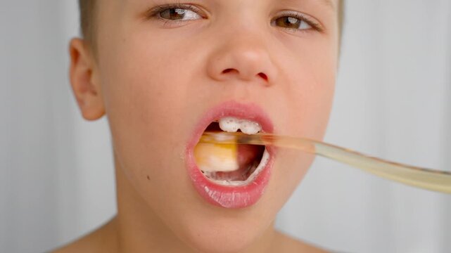 A 7-year-old boy brushes his teeth with a toothbrush and toothpaste. Good oral hygiene is essential for maintaining good health from childhood. 