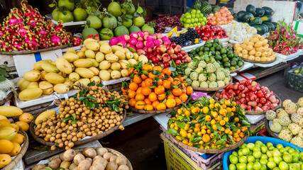 A vibrant Asian market stall displaying an array of fresh tropical fruits, perfect for celebrating Lunar New Year