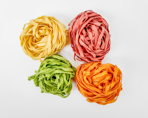 Four colorful nests of fresh pasta symbolize culinary creativity and diversity, perfect for Italian cuisine or festive meal planning