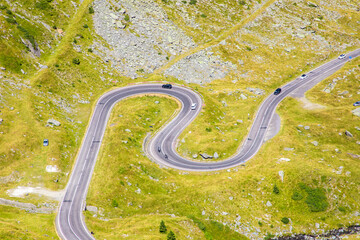Aerial view of a winding road on a mountain slope, curves seen from above