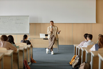 Wide angle shot of adult male teacher lecturing students on civil law speaking in hand held...