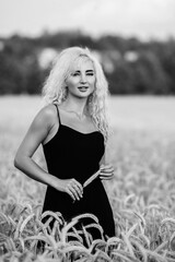 Portrait of a young beautiful blonde girl in nature. Black and white photo.