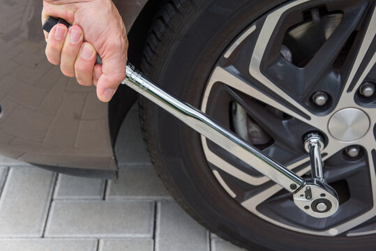 Man pulling in tyre with a torque moment wrench
