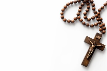 Wooden cross with rosary beads and crucifix on a white background with an empty copy space for text