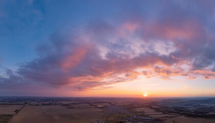 Ideal for Sky replacement project: Panoramic, colorful pink-orange-blue dramatic sky with clouds illuminated by red sunset, aerial photography, far horizon without obstacles.