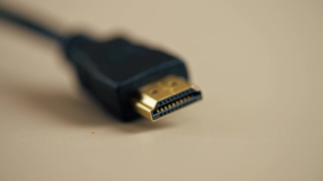 close-up on light beige table there is an HDMI cable for connecting the monitor power supply wired power