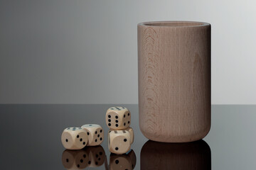 drewniane kości do gry i kubek do kości jako symbol hazardu © Henryk Niestrój