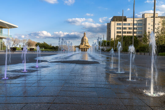 Fountains line leading to Alberta Legislature Building, Edmonton, Canada with blue sky and clouds background