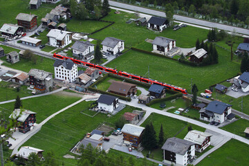 Aerial view of the Swiss town of Rand, a red train arrives in town