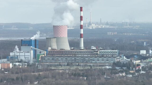 Aerial drone view of the chimneys of a coal fired power plant.Large chimneys of the power plant cooling tower. Drone flight past the power plant. Industrial Power plant in Bedzin, Poland.