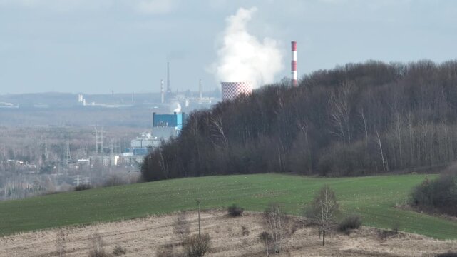 Aerial drone view of the chimneys of a coal fired power plant.Large chimneys of the power plant cooling tower. Drone flight past the power plant. Industrial Power plant in Bedzin, Poland.
