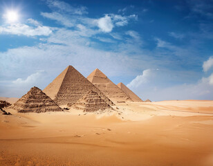 The great pyramids of Giza in Egypt under the vibrant blue sky with clouds