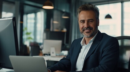 Portrait of a smiling businessman working on a laptop