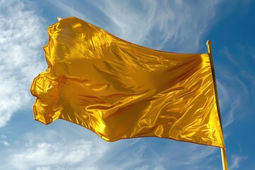 A yellow flag waves against a clear blue sky, symbolizing positivity, caution, or a signal, with a vibrant and bright appearance.