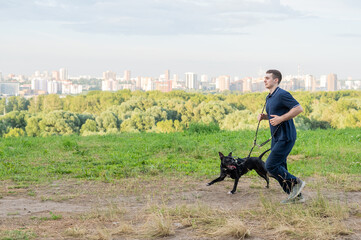 Man running with pit bull terrier outdoors. 